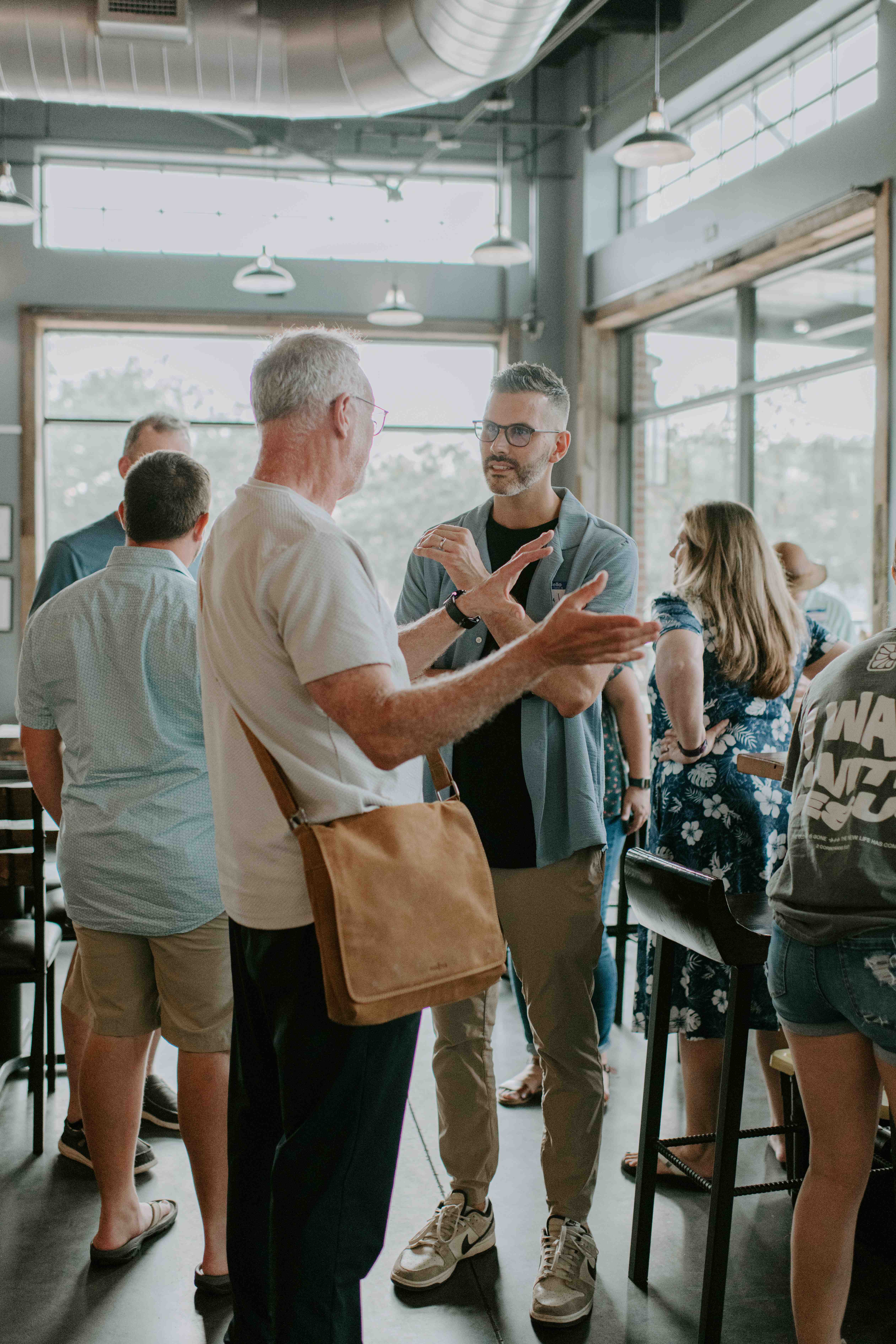 A team member at Church in the Garden wearing a name tag talks with guests after a gathering