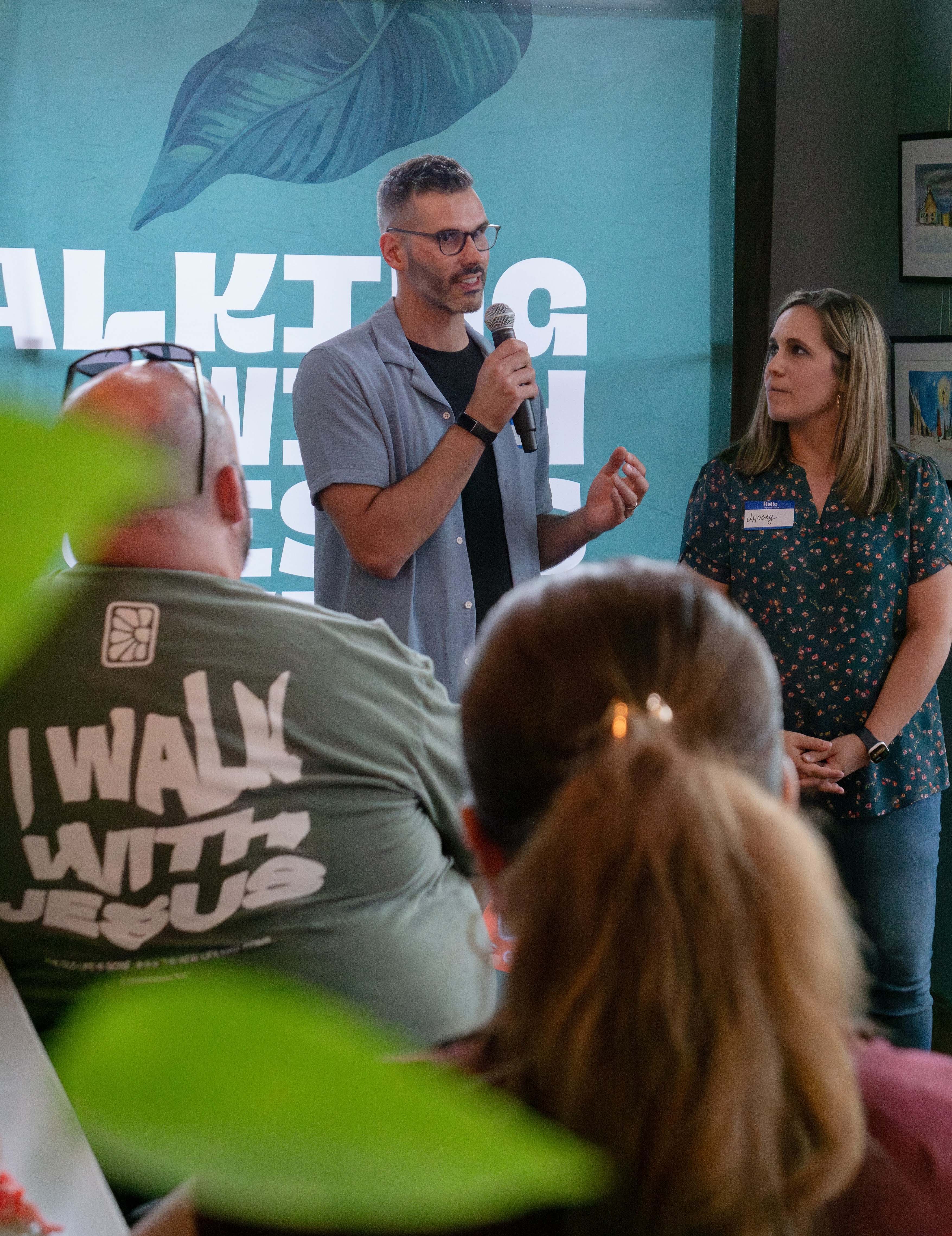 A pastor shares a message on a microphone during a Church in the Garden gathering